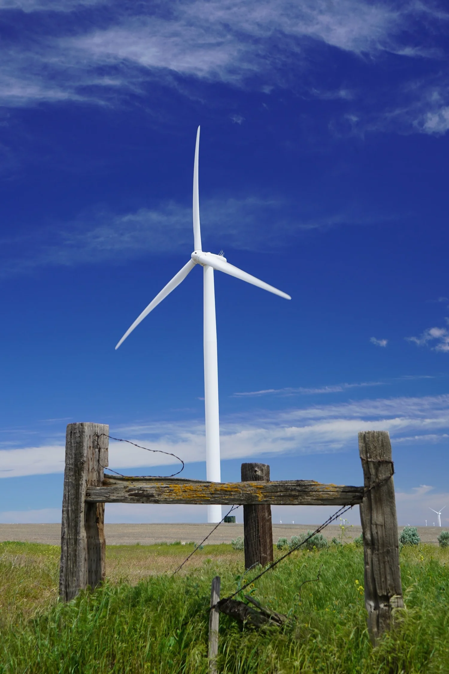 A windmill behind a ruined fence